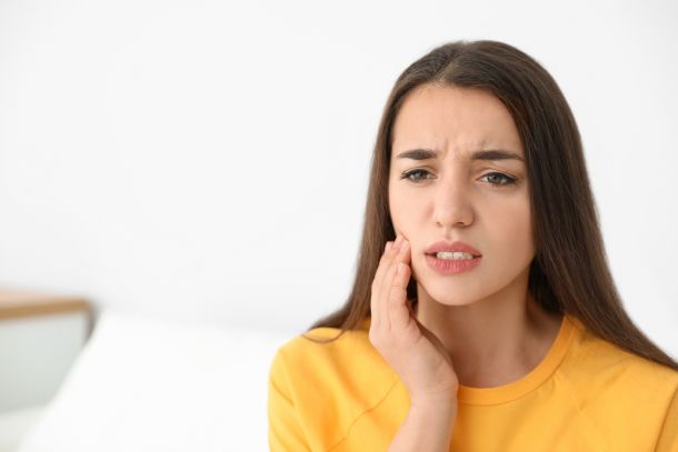 woman with orthodontic emergency in yellow shirt